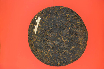 China Yunnan Puer tea cake. Red background. Minimalism. Copy space. Mockup.