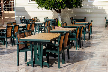 Chairs and tables in cozy outdoor cafe at summer