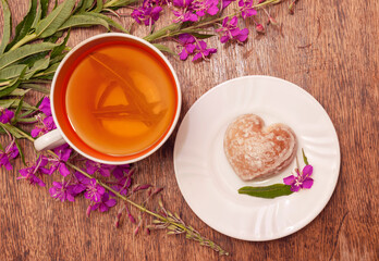 Still life photo with herbal tea from fireweed leaves and gingerbread on a wooden background
