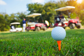 Golf ball on tee in the evening golf course with sunshine background.