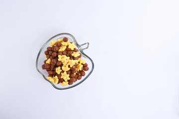 A bowl of chocolate and corn cereal in the glass bowl isolated on white background 