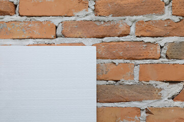 Styrofoam, polystyrene thermal insulation at brick wall, house renovation