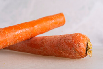 Carrots being Sliced on White Cutting Board With Chef's Knife and Wood Stand