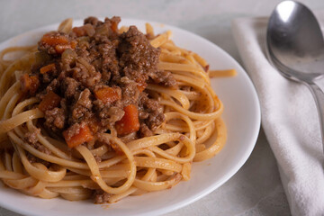 White Plate of Pasta alla Bolognese with Meat Sauce, Cheese and Vegetables