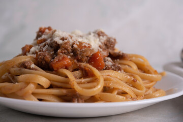 White Plate of Pasta alla Bolognese with Meat Sauce, Cheese and Vegetables