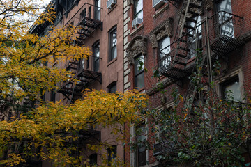 Row of Old Brick Apartment Buildings in Greenwich Village of New York City with Colorful Trees during Autumn