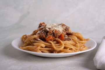 White Plate of Pasta alla Bolognese with Meat Sauce, Cheese and Vegetables