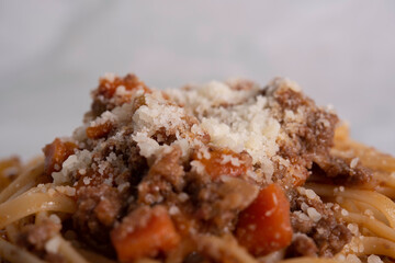 White Plate of Pasta alla Bolognese with Meat Sauce, Cheese and Vegetables