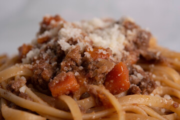 White Plate of Pasta alla Bolognese with Meat Sauce, Cheese and Vegetables