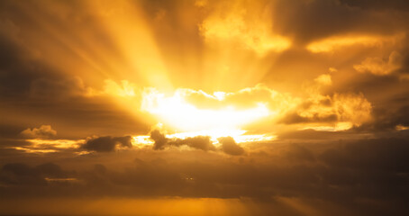 Orange clouds crossed by bright sunlight