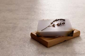 Soap bar with lavender flower on wooden soap holder. Handmade herbal cosmetic for beauty and skin care.