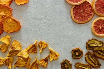 Dried dehydrated fruits on bright background with copy space. Healthy natural flavor snacks: pineapple, persimmon, kiwi and grapefruit chips.
