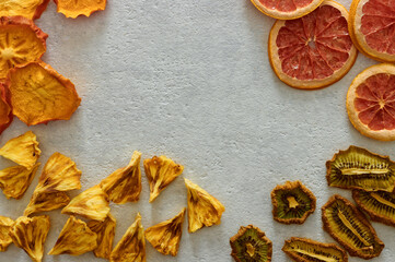 Fototapeta na wymiar Dried dehydrated fruits on bright background with copy space. Healthy natural flavor snacks: pineapple, persimmon, kiwi and grapefruit chips.