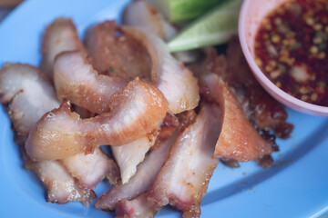 Tasty slice grilled pork served with spicy dipping sauce and vegetable side.