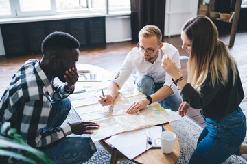 Group of diverse colleagues studying map together