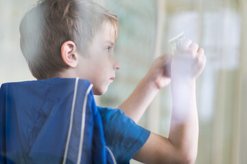 Small boy checking watermarks on the dollar bill
