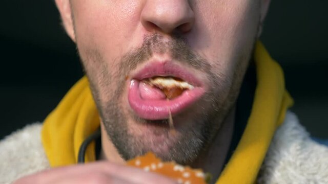 portrait of angry man eating hamburger at fast food cafe.