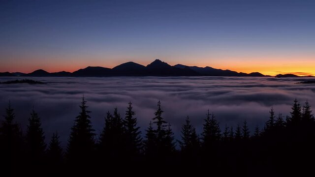 Beauty of Peaceful evening nature in summer mountains landscape after sunset above foggy clouds in forest Time lapse