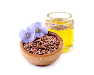 Flax seeds in wooden bowl with flowersand linen oil on white background.
