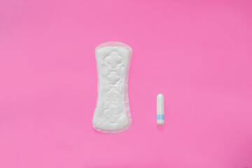 The menstrual cycle in women. Choose between a tampon and a feminine pad on a pink background.
copy space. top view
