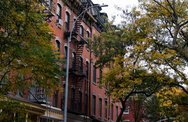 Fototapeta premium Row of Old Brick Apartment Buildings in Greenwich Village of New York City with Colorful Trees during Autumn
