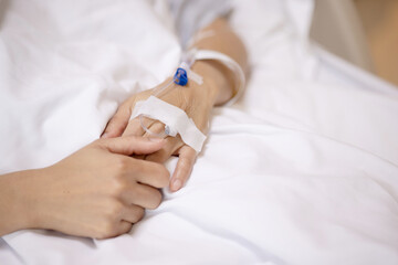 Hand was pierced with a Saline water hose In a hospital bed. Medical treatment to keep the patient healthy. Concept Health care