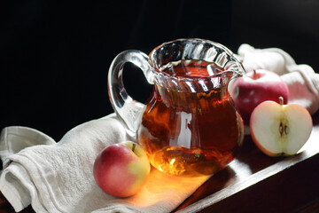 Apple vinegar, malt fruit cider drink in a glass decanter on dark black background, closeup, copy space, healthy drink used in natural cosmetics, as cleaner and body care