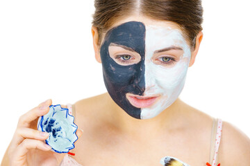Girl black mask on half face apply white mud