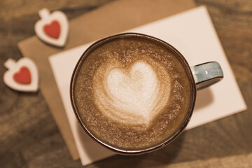 Beautiful cup of coffee with a heart shape on a wooden background. Valentine's day concept. Selective focus.