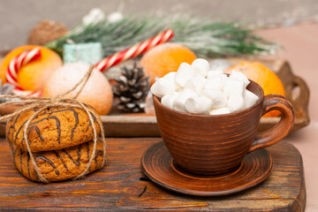 Coffee with marshmallows in cup of red clay and oatmeal cookies in winter composition. Christmas breakfast, Valentine's day. Close-up, selective focus