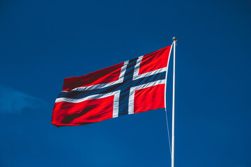 Flag of Norway on the blue sky background. Space for your text message or promotional content