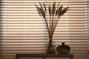 Decorative vases on commode near window indoors, space for text