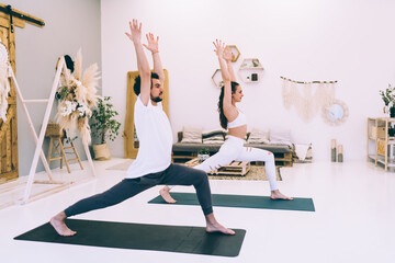 Sporty woman practicing Anjaneyasana with coach