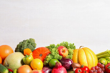 Assortment of fresh organic fruits and vegetables on light background, closeup. Space for text