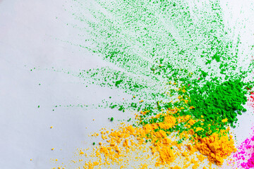 Happy Holi - gulal or holi powder splatter on white background.+++