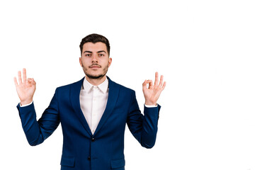 Young businessman concentrated and meditating, feeling satisfied and relaxed, thinking isolated on a white background