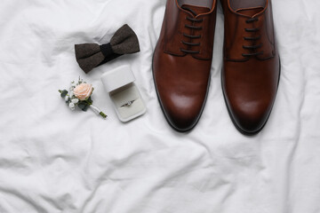 Flat lay composition with wedding shoes on white fabric, space for text
