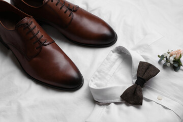 Wedding shoes and shirt on white fabric