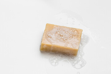 Soap bar and foam on white background