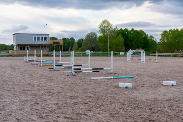 Wooden barriers, equestrian obstacles, barriers on the sand ground for jumping horses and riders at riding school