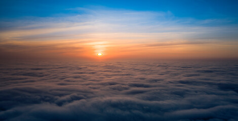 Fototapeta na wymiar Dawn or sunset over the clouds, blue hour, aerial view.