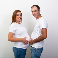 Pregnancy. Happy Family Expecting Baby. Man and a pregnant woman are measured by bellies. Couple lifestyle