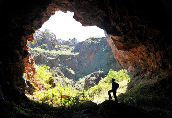 Silueta de hombre dentro de una cueva en el Cerro del Hierro, Parque Natural Sierra Norte de...