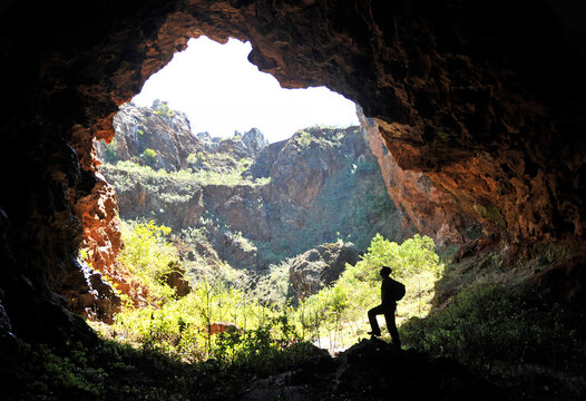 Silueta de hombre dentro de una cueva en el Cerro del Hierro, Parque Natural Sierra Norte de Sevilla, España.