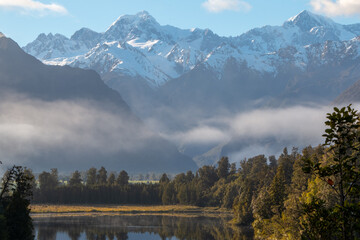 Lake Matheson in Westland Tai Poutini National Park on the New Zealand West Coast with a view of the Southern Alps, specifically Mount Tasman (Horokoau) and Mount Cook (Aoraki)