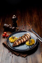 Grilled chicken breast with mashed potatoes, clay blue dish, dark wooden table