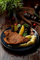 Austrian schnitzel with pickles and potato in a restaurant, top view