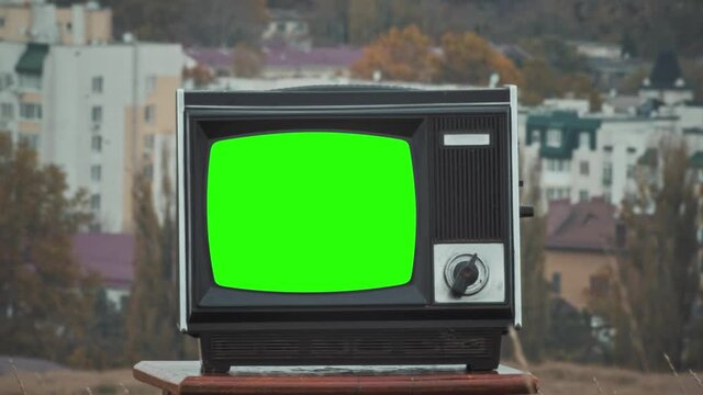 Old TV agains green background. Crash zoom effect
