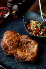 Roasted greasy pork steak, dark atmospheric photo for a food magazine