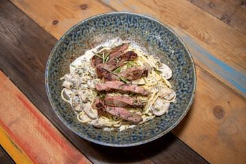 A plate of delicious steak and creamy mushroom linguine